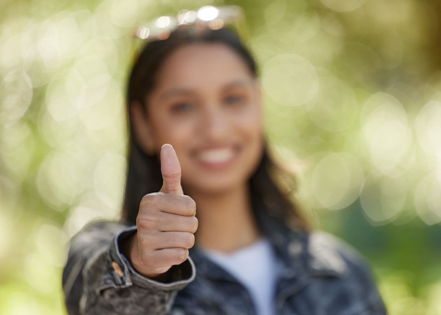 Education for the win. Shot of a young woman showing the thumbs up while standing outside